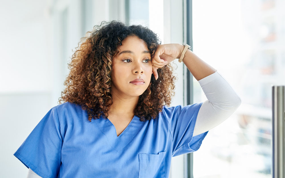 stressed healthcare worker with curly hair 